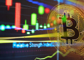 moneda de bitcoin sobre pantalla con grafico de precio digital