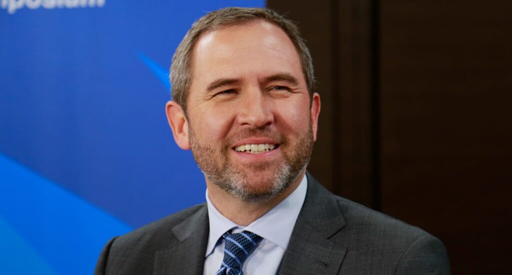 Fotografía del CEO de Ripple Labs, Brad Garlinghouse, sonriendo en lo que parece una entrevista.