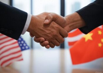 dos manos estrechándose y de fondos las banderas chinas y de estados unidos