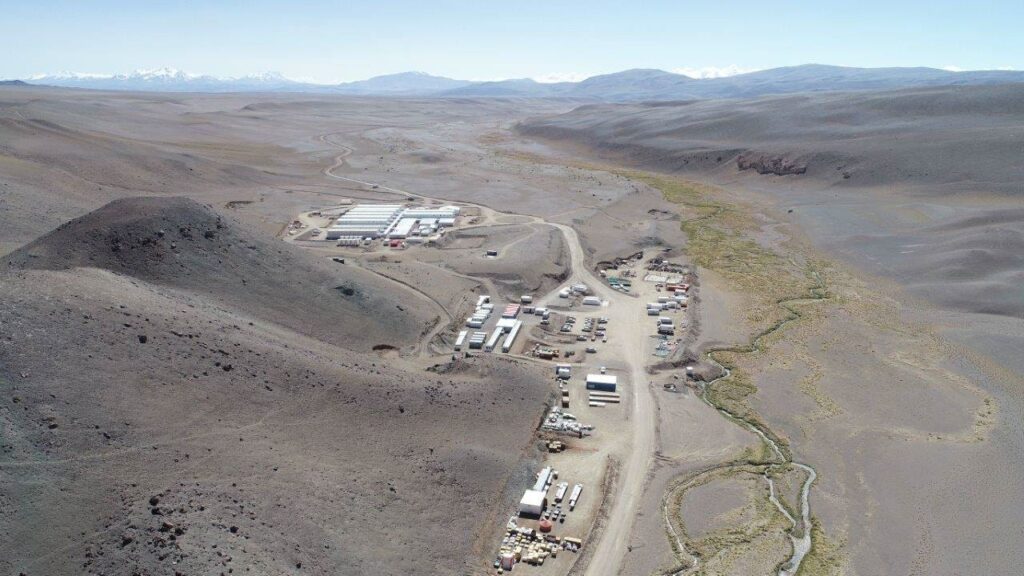 un paisaje desértico con varias estructuras tipo edificios y vehículos.
