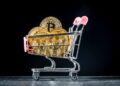 Carro de mercado con monedas físicas de bitcoin en su interior.