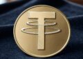 Una moneda dorada con el logo de la empresa Tether.