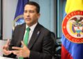 Luis Eduardo Llinás en su oficina junto con una badera de Colombia.