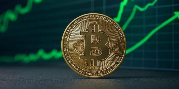 Bitcoin en un escritorio con gráficas en verde en el fondo.