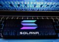 Un teléfono con el logo de Solana sobre una laptop.