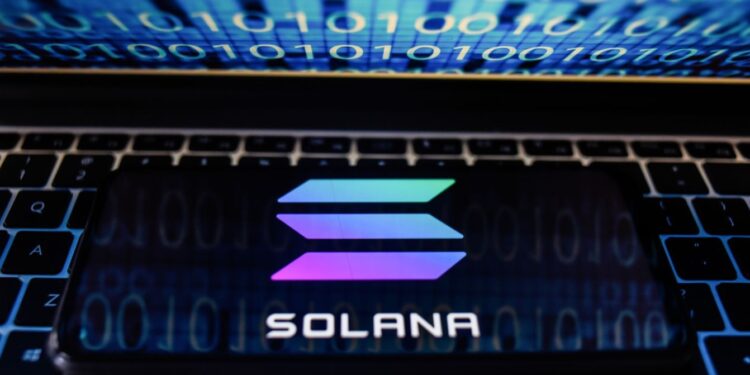 Un teléfono con el logo de Solana sobre una laptop.