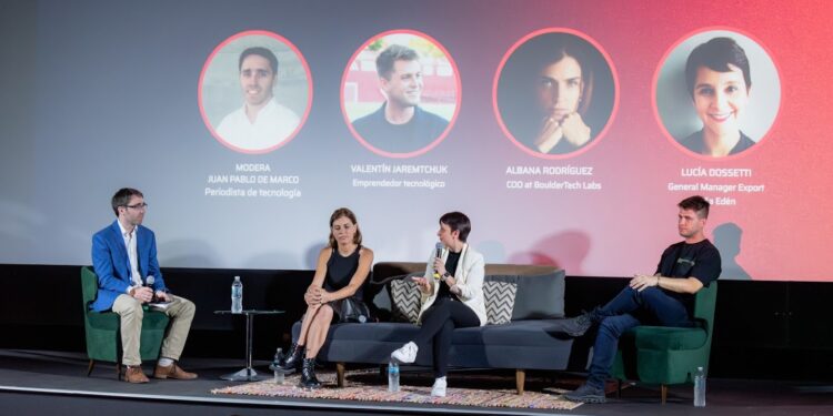 Panel de discusión en un evento de blockchain con cuatro oradores y un moderador.