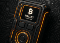 Un dispositivo electrónico de color negro y naranja con el logo de Bitcoin, junto a un fondo oscuro tecnológico.