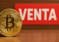 Bitcoin con un letrero de venta en el fondo.