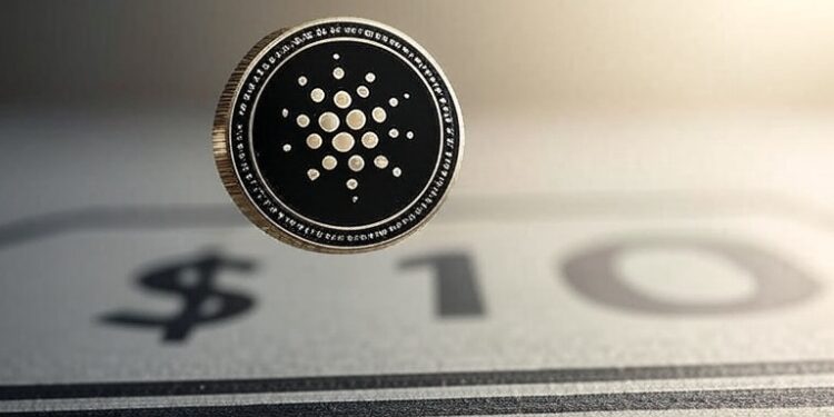 Una moneda de cardano sobre un dibujo de 10 dólares.