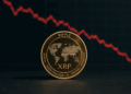 Moneda dorada de XRP con un gráfico de precios en rojo.