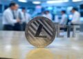 Una moneda de litecoin junto a las siglas ETF.