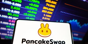 teléfono móvil con el logo de PancakeSwap y gráficos de fondos.