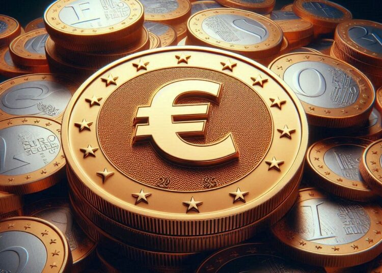 una moneda dorada con el logo del euro en el centro y con un lote de monedas en el fondo.