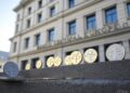 Banco Central de Europa en el fondo y monedas de Tether al frente.