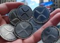 monedas de XRP en una mano.