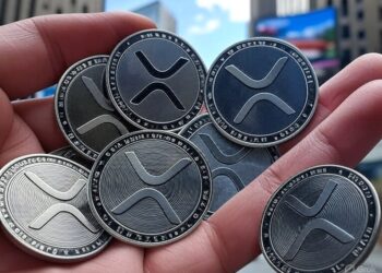 monedas de XRP en una mano.