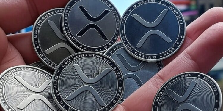 monedas de XRP en una mano.