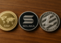 Monedas físicas de XRP, solana y litecoin.