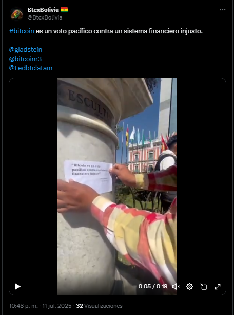 Una persona colocando un cartel sobre bitcoin en un muro frente a un palacio de gobierno de Bolivia.