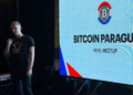 El logo de la comunidad Bitcoin Paraguay proyectada en una pantalla durante un meetup.