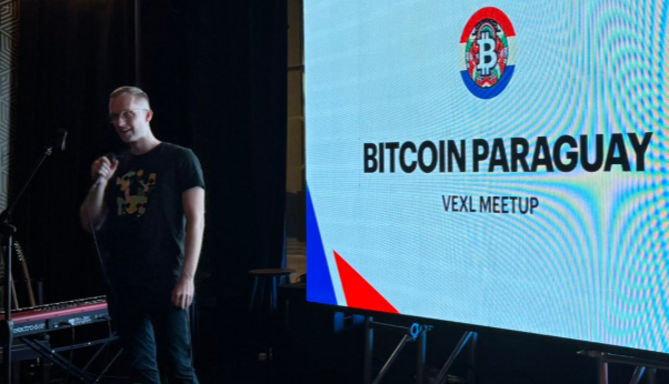 El logo de la comunidad Bitcoin Paraguay proyectada en una pantalla durante un meetup.