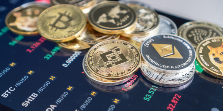 monedas de ethereum, ethereum classic, bitcoin. dogecoin, ripple, cardano y otras apiladas de forma dispersa sobre pantalla de telefono movil con información del rendimiento de prcio del mercado de criptomonedas en pantalla