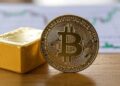 Bitcoin al lado de un lingote de oro.