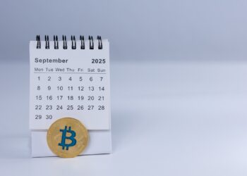 Moneda de bitcoin y calendario abierto en septiembre de 2025.