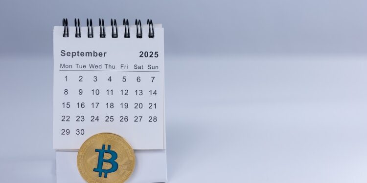 Moneda de bitcoin y calendario abierto en septiembre de 2025.