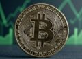 Bitcoin con gráficas verdes de fondo.