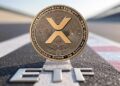 Una moneda de XRP transitando una recta que dice ETF.