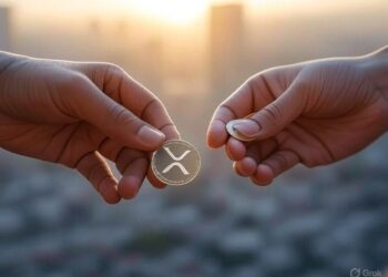 Dos manos y una moneda dorada de XRP.