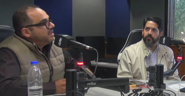 Anibal Garrido y Asdrúbal Oliveros conversan frente a micrófonos.