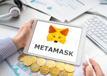 Una persona con una tablet en sus manos. En la pantalla se ve el logo de Metamask