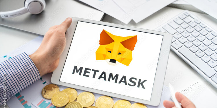 Una persona con una tablet en sus manos. En la pantalla se ve el logo de Metamask
