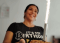 Una mujer luce una camiseta con el logo de bitcoin.