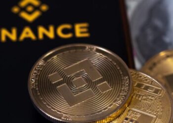 Una criptomoneda de BNB delante del logo de Binance