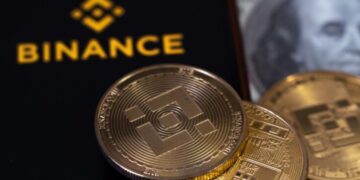 Una criptomoneda de BNB delante del logo de Binance