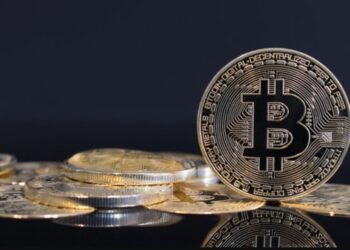 Una moneda de bitcoin está sobre una mesa.
