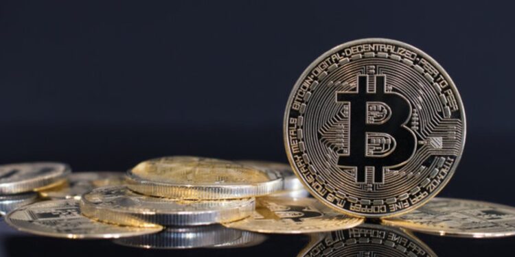 Una moneda de bitcoin está sobre una mesa.