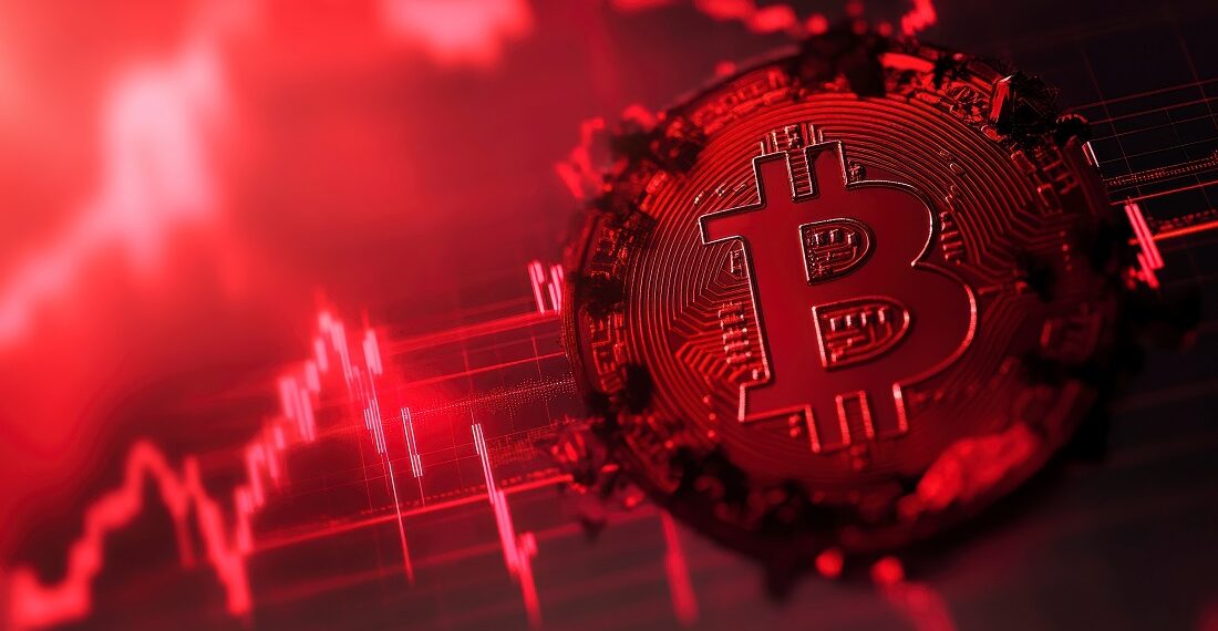 Moneda de bitcoin en un gráfico teñido de rojo.