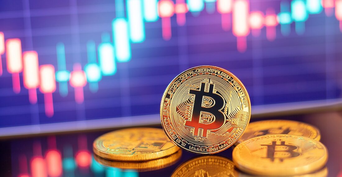 Monedas físicas de bitcoin y gráfico de precio.