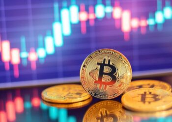 Bitcoin con gráficas de precio en el fondo.