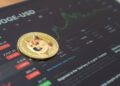 moneda de dogecoin sobre pantalla mostrando grafico de precio en alza dentro de plataforma de trading