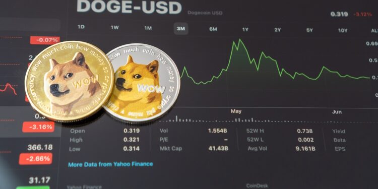Dos monedas físicas de dogecoin (DOGE) y un gráfico de precios.