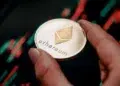 Una moneda dorada de Ethereum delante de un gráfico de precios.
