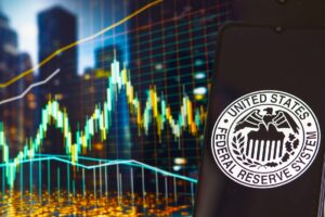 Gráfico de precio genérico y teléfono móvil con el logo de la Reserva Federal de Estados Unidos.