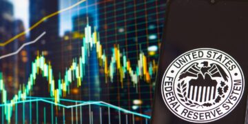 Gráfico de precio genérico y teléfono móvil con el logo de la Reserva Federal de Estados Unidos.