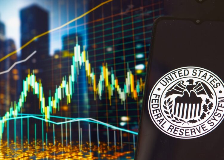 Gráfico de precio genérico y teléfono móvil con el logo de la Reserva Federal de Estados Unidos.